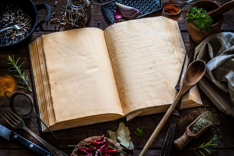 Vintage cookbook with kitchen utensils (Getty Images/fcafotodigital)