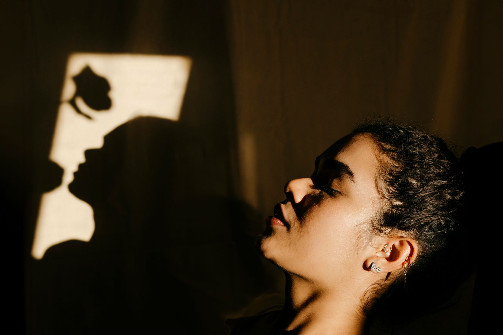 Portrait of a young woman, with the shadow of a rose (Getty Images/Westend61)