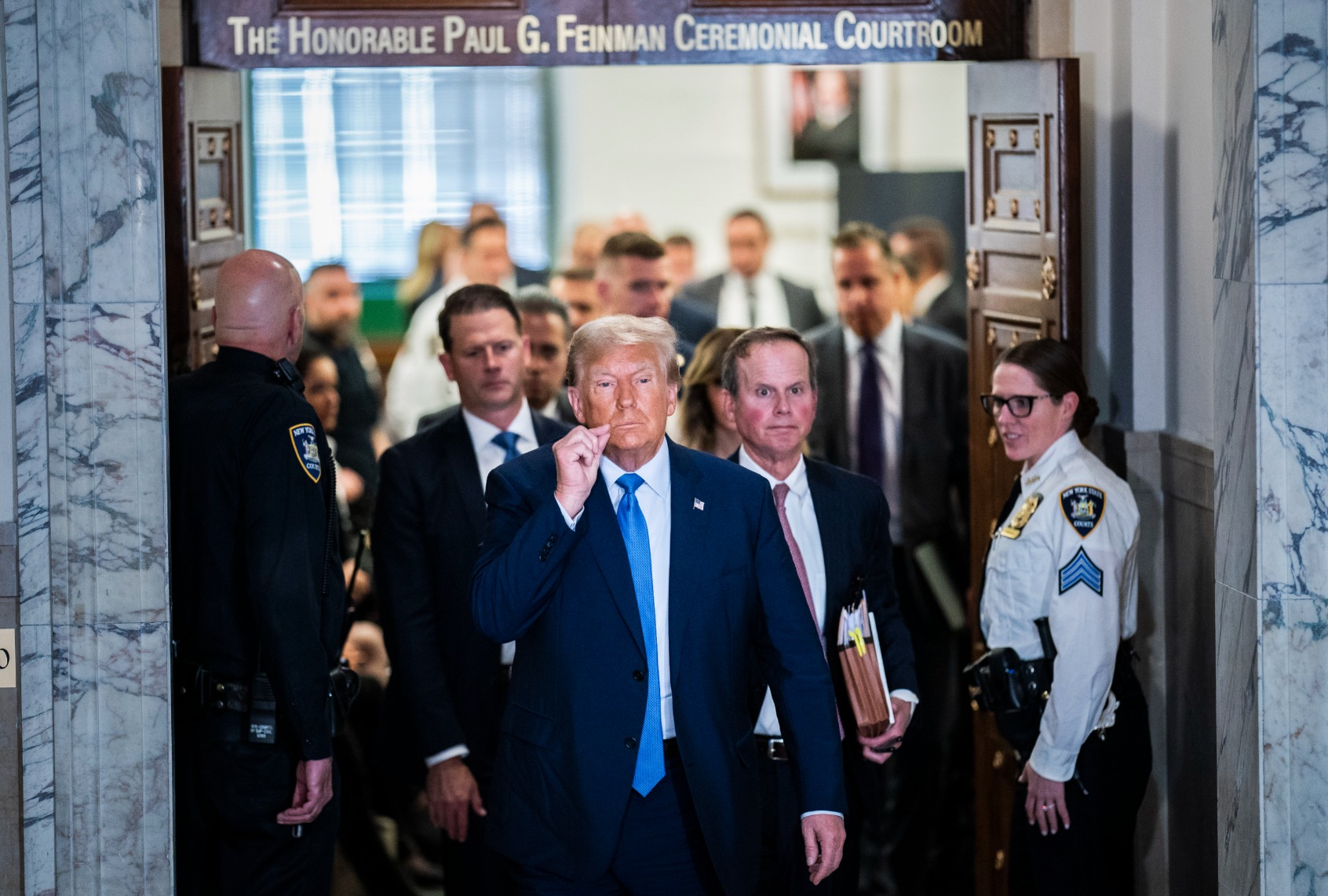 Former President Donald Trump gestures a zipped lip as he walks out of the courtroom during a break before testifying in his civil fraud case at the State Supreme Court of New York on Monday, Nov. 06, 2023. (Jabin Botsford/The Washington Post via Getty Images)
