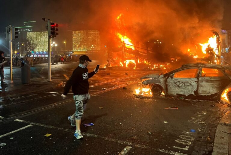 Flames rise from a car and a bus, set alight at the junction of Bachelors Walk and the O'Connell Bridge, in Dublin on November 23, 2023, as people took to the streets in protest following the stabbings earlier in the day. Protesters in Dublin on Thursday torched a car and fought police, an AFP journalist reported, after three children were injured in a suspected school stabbing that social media rumors attributed to a foreign national. (PETER MURPHY/AFP via Getty Images)