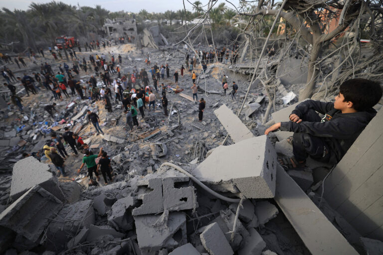 A child looks at the rubble of a house after an Israeli strike in Khan Yunis, in the southern Gaza Strip on November 22, 2023, amid ongoing battles between Israel and the Palestinian Hamas movement. (MAHMUD HAMS/AFP via Getty Images)