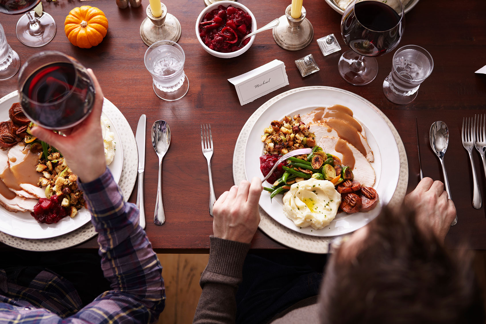 Overhead of two men eating holiday meal (Getty Images/Maren Caruso)