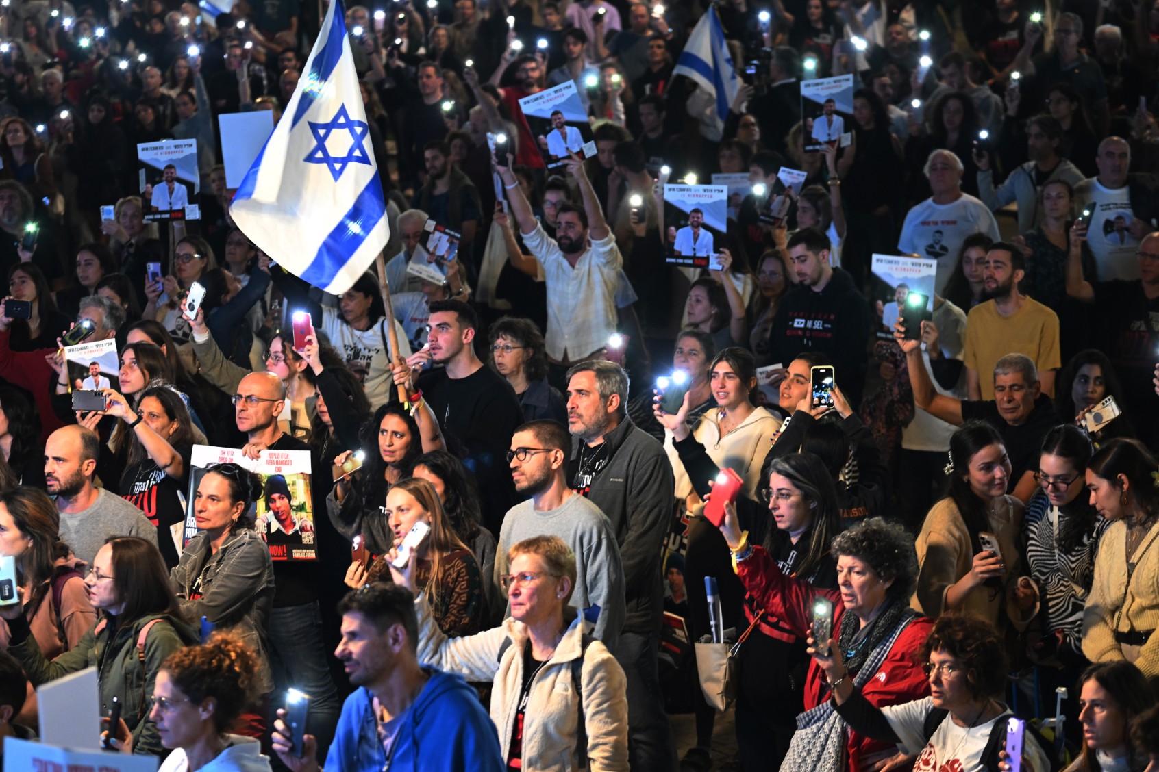 Thousands of people and the families of hostages hold up their mobile phones to sing the national anthem during the ‘50 Days of Hell’ rally in support of the 212 hostages that are still being held by Hamas. (Alexi J. Rosenfeld/Getty Images)