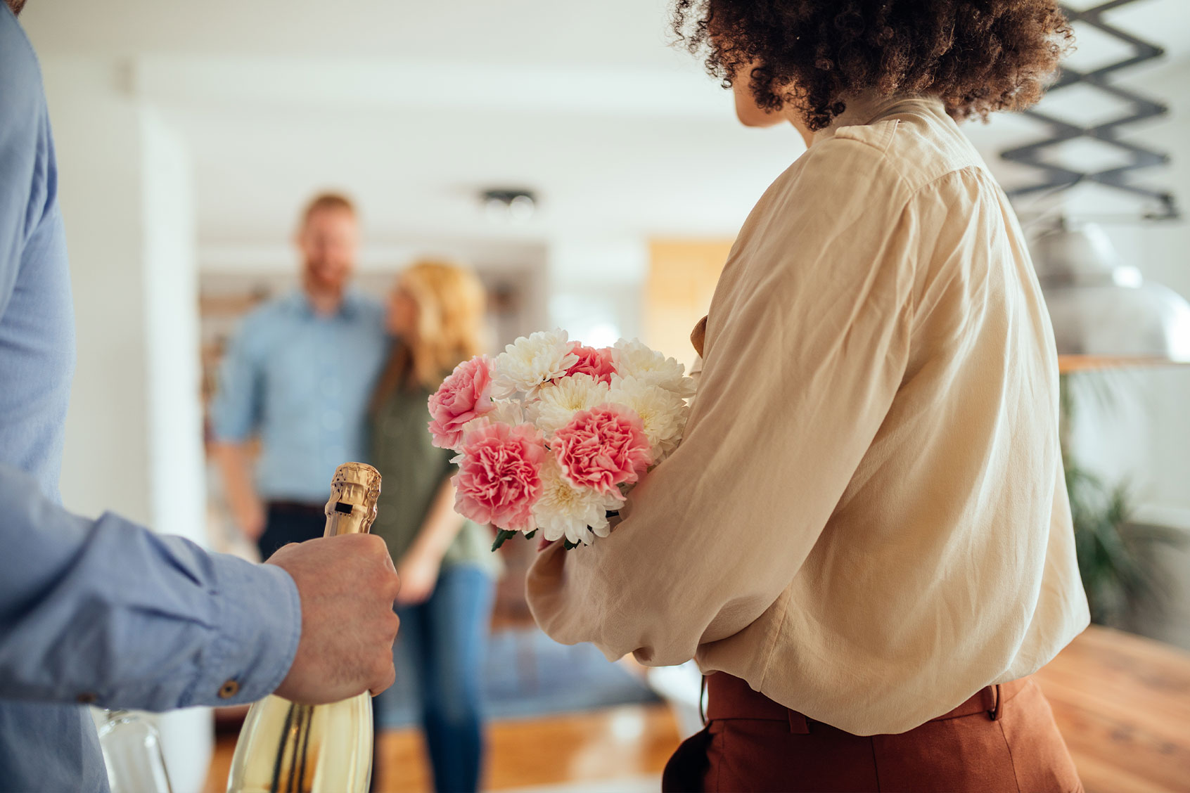 Cropped shot of a young couple visiting friends in their new home (Getty Images/bernardbodo)