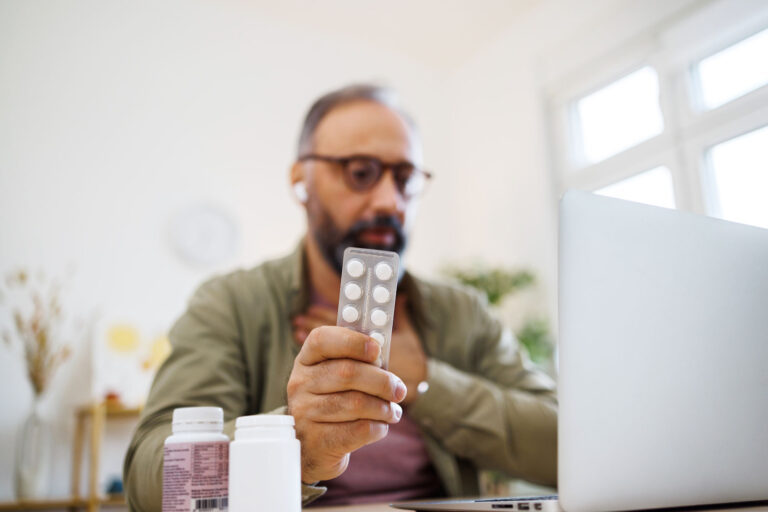 Man consulting his doctor about drug medicine online (Getty Images/mixetto)