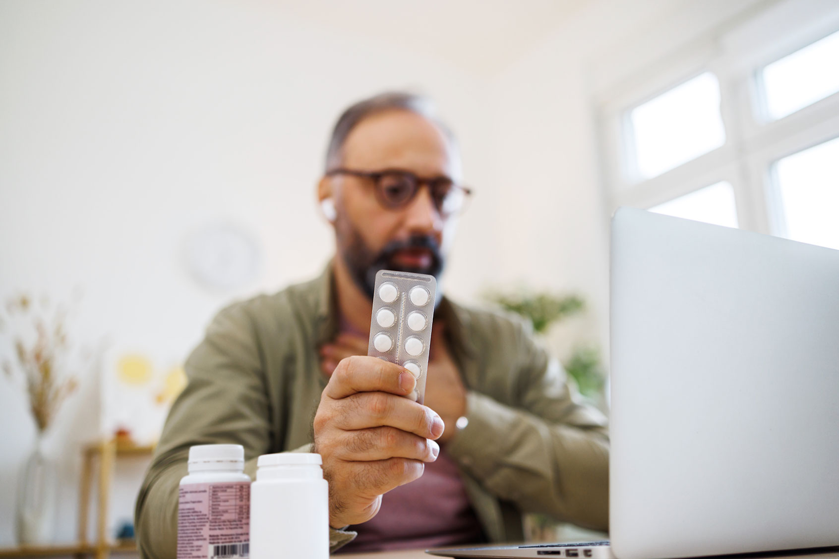 Man consulting his doctor about drug medicine online (Getty Images/mixetto)
