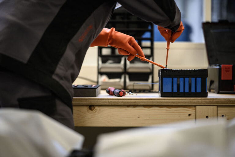 A mechanic works on a battery module of an electric car, at the Revolte e-garage specialized in the electric car repairs, in Carquefou, western France, on November 30, 2022. (LOIC VENANCE/AFP via Getty Images)