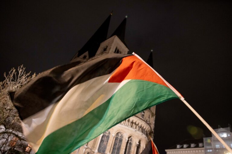 A Palestinian flag is waved in front of Bonn Minster during the "Stop the genocide in Gaza" demonstration on the war in the Middle East. ( Thomas Banneyer/picture alliance via Getty Images)