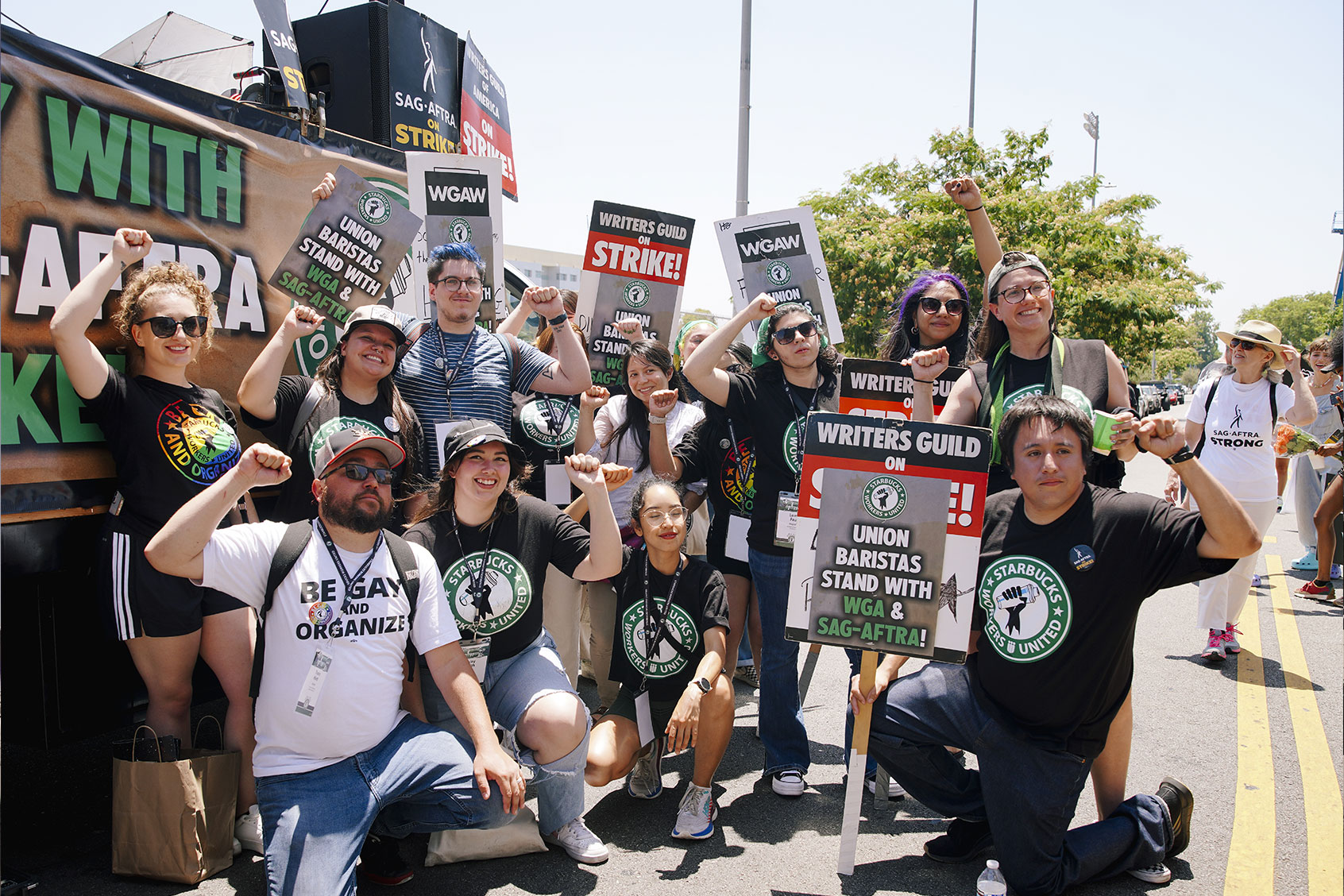 Starbucks union members pose as they join The Screen Actors Guild - American Federation of Television and Radio Artists (SAG-AFTRA) and Writers Guild of America (WGA) union members on the picket line as they continue their strike in Los Angeles, California, United States on July 28, 2023. (Katie McTiernan/Anadolu Agency via Getty Images)