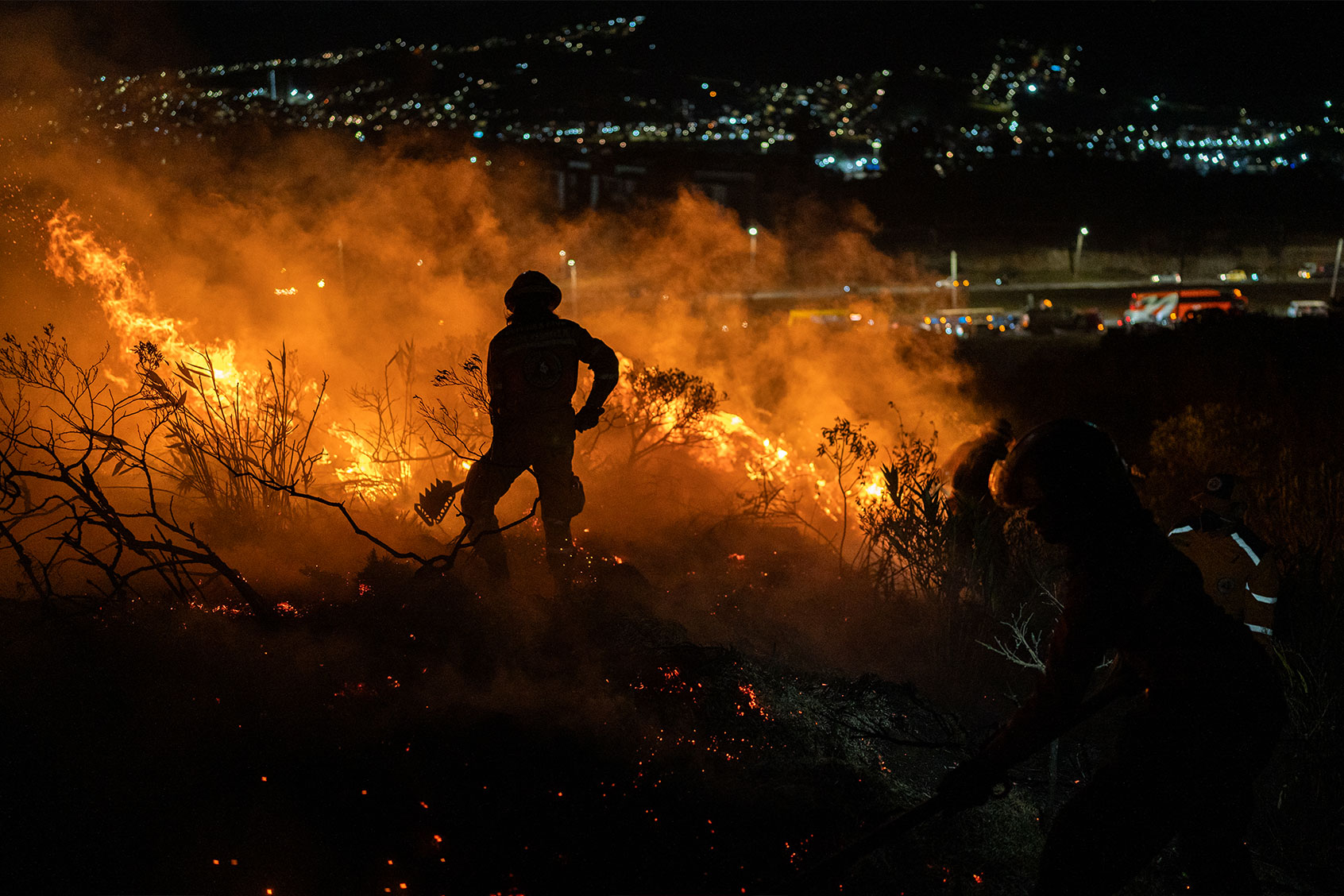 Rescuers work to extinguis a forest fire near the "Doña Juana" dump on January 24, 2024 in Bogota, Colombia. (Diego Cuevas/Getty Images)