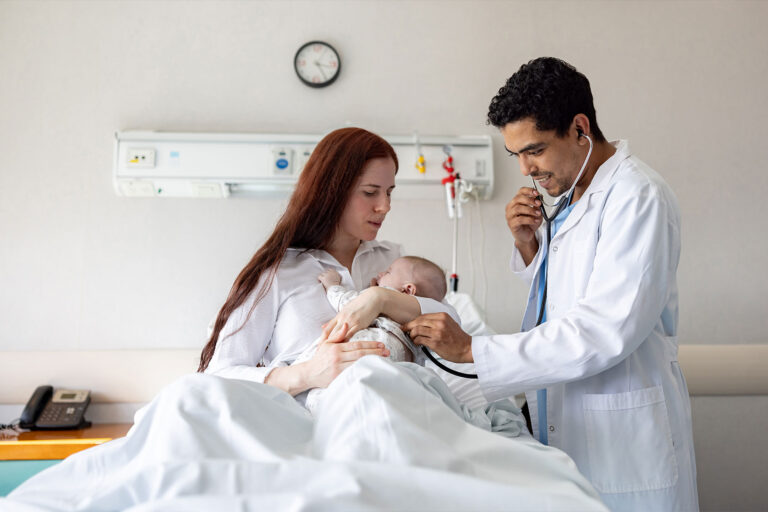 Doctor examining a newborn baby at a maternity hospital and listening to his heartbeat (Getty Images/andresr)