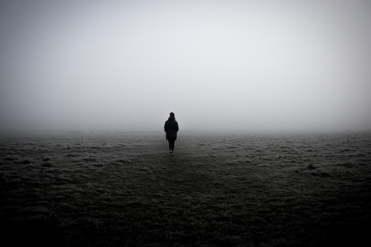 A closeup of a woman walking in a foggy field (Wirestock / Getty Images)