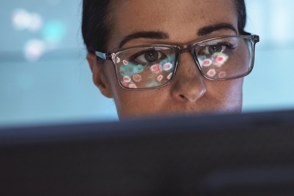 Scientist viewing an electron micrograph of virus particles on a screen (TEK IMAGE/SCIENCE PHOTO LIBRARY / Getty Images)