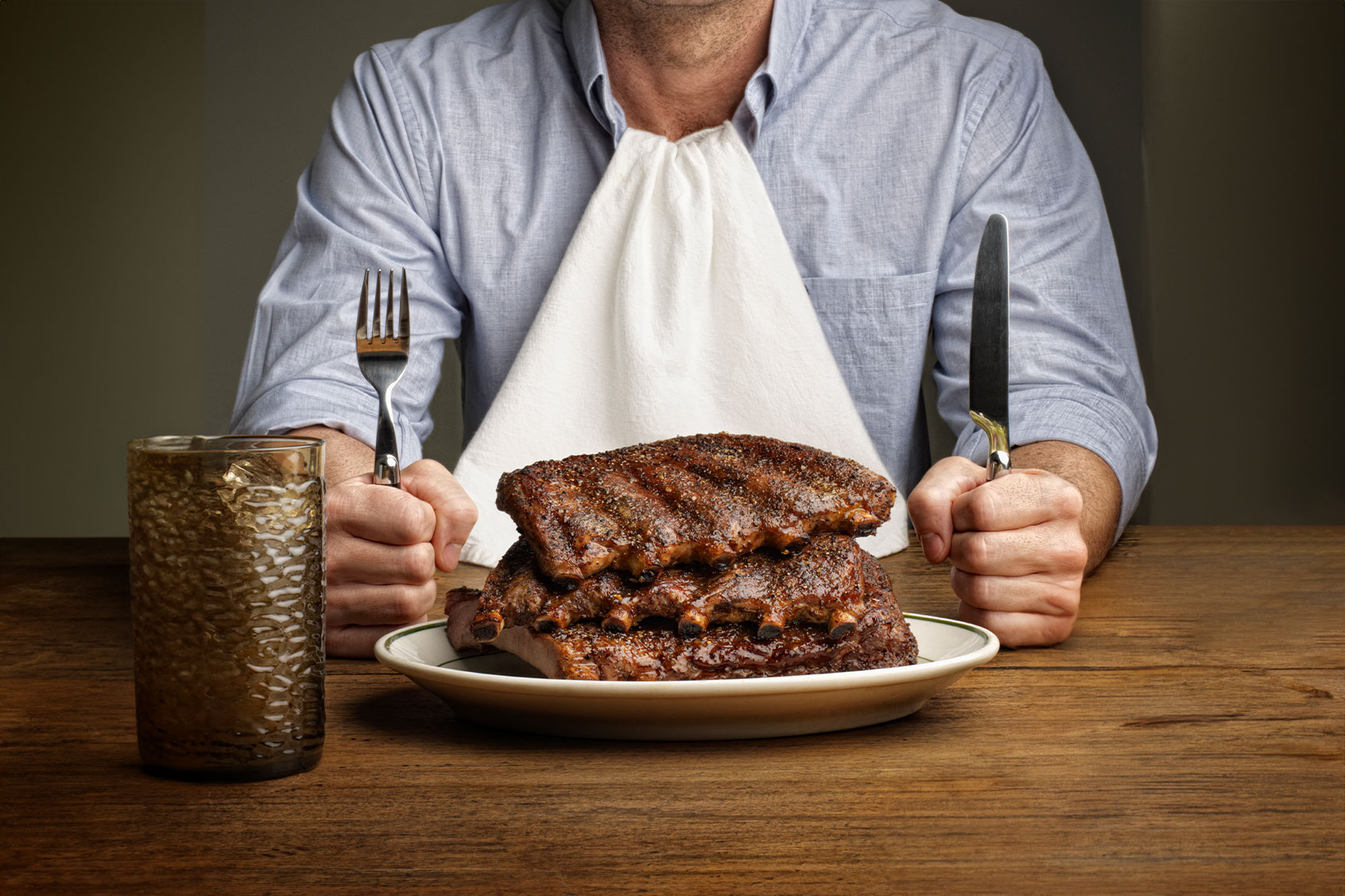 Man about to eat large stack of ribs (Getty Images/RF Pictures)