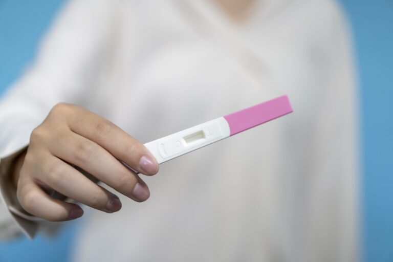 A woman holds a pregnancy test. (Longhua Liao)