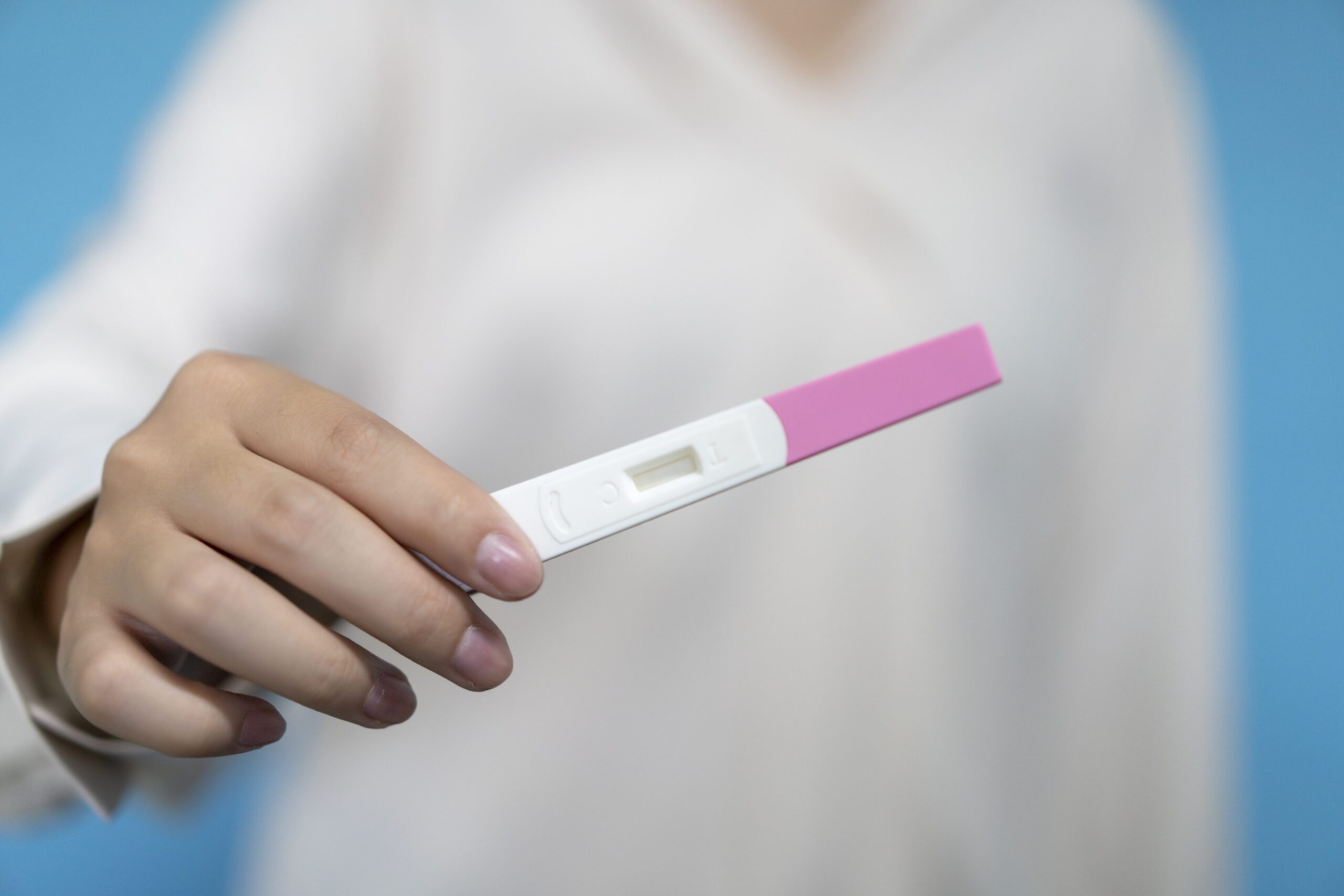A woman holds a pregnancy test. (Longhua Liao)