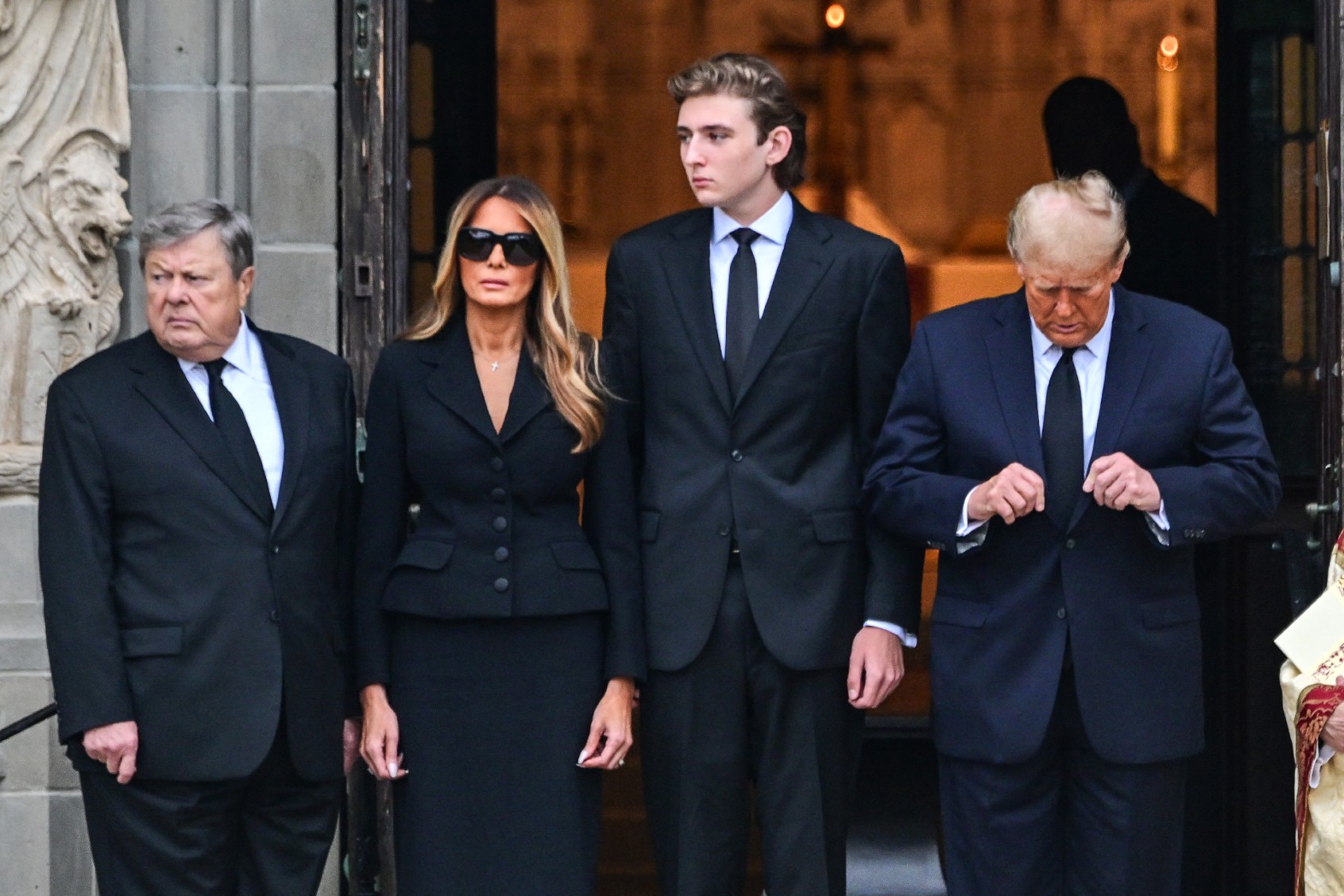 Former U.S. President Donald Trump (R) stands with his wife Melania Trump (2L) their son Barron Trump (C) and father-in-law Viktor Knavs, at the start of a funeral for Amalija Knavs, the former first lady's mother, outside the Church of Bethesda-by-the-Sea, in Palm Beach, Florida, on January 18, 2024. (GIORGIO VIERA/AFP via Getty Images)