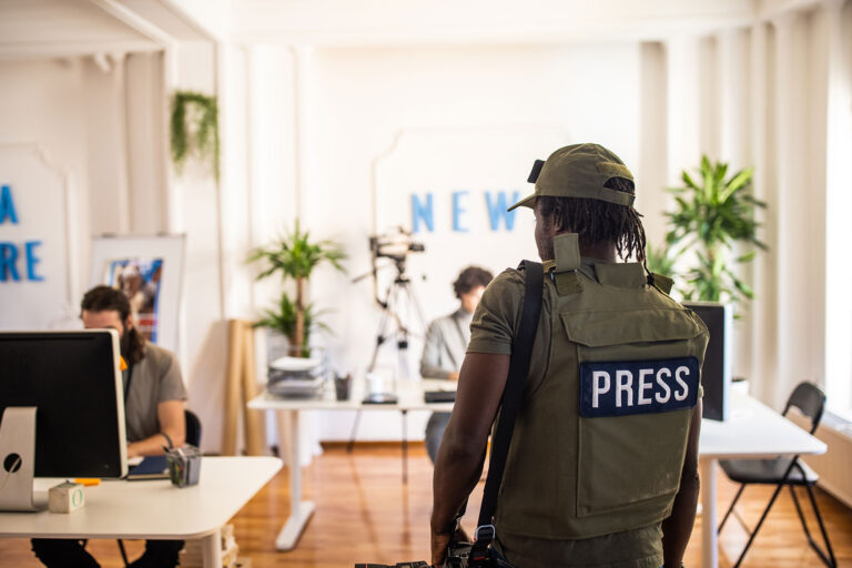 Rear view of male editorial photographer arriving at the editorial office (Getty Images/miodrag ignjatovic)