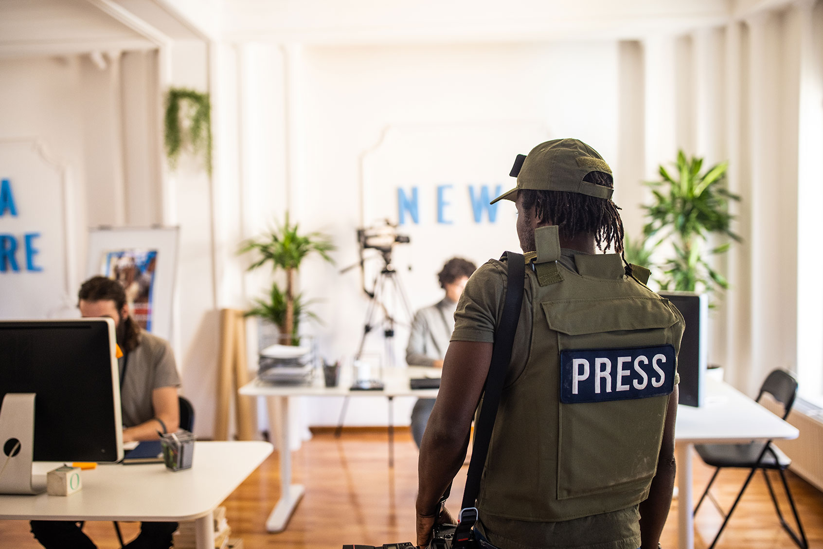 Rear view of male editorial photographer arriving at the editorial office (Getty Images/miodrag ignjatovic)