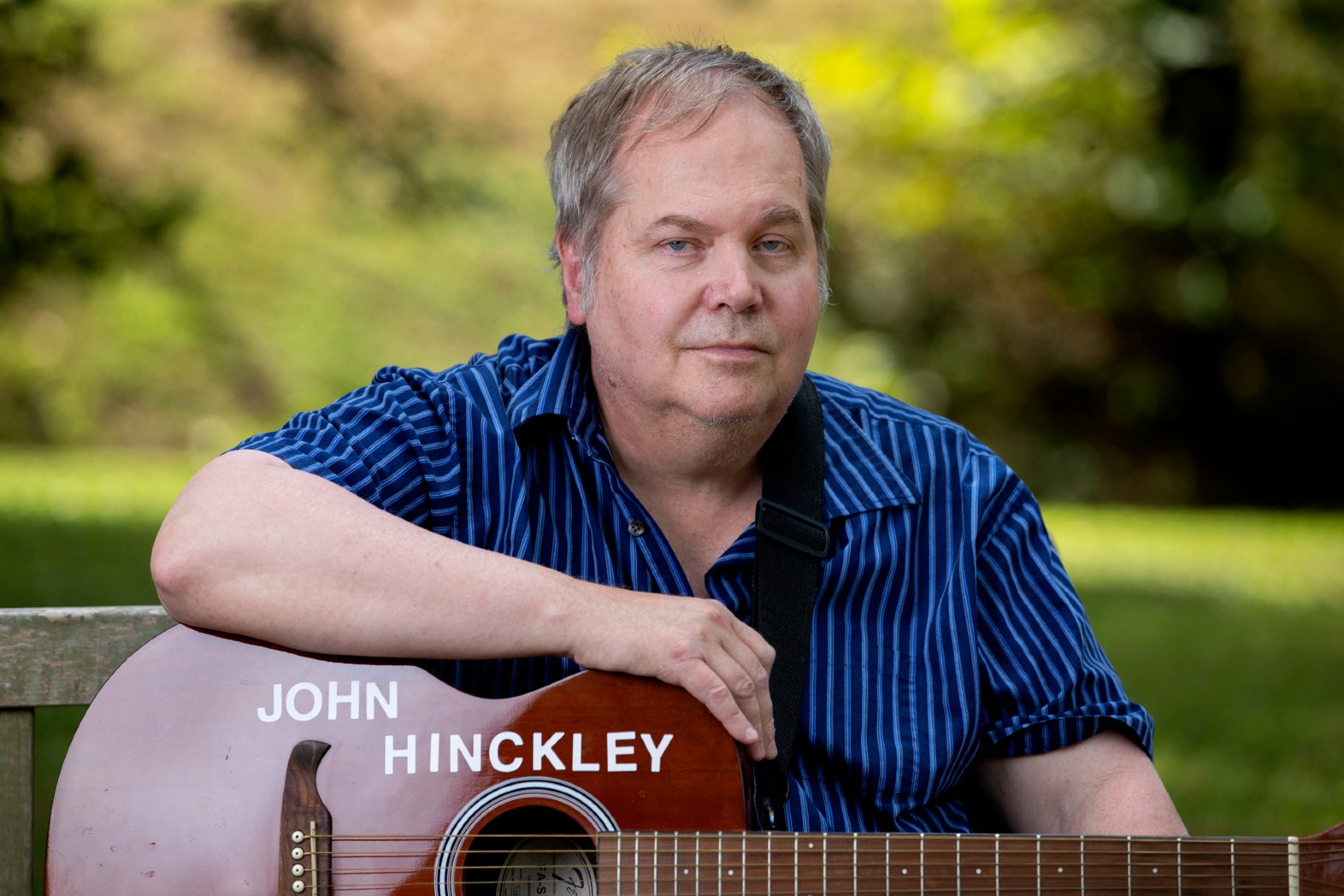 John Hinckley Jr. sits for a portrait with his guitar in Williamsburg, Virginia, on September 14, 2022. (RYAN M. KELLY/AFP via Getty Images)