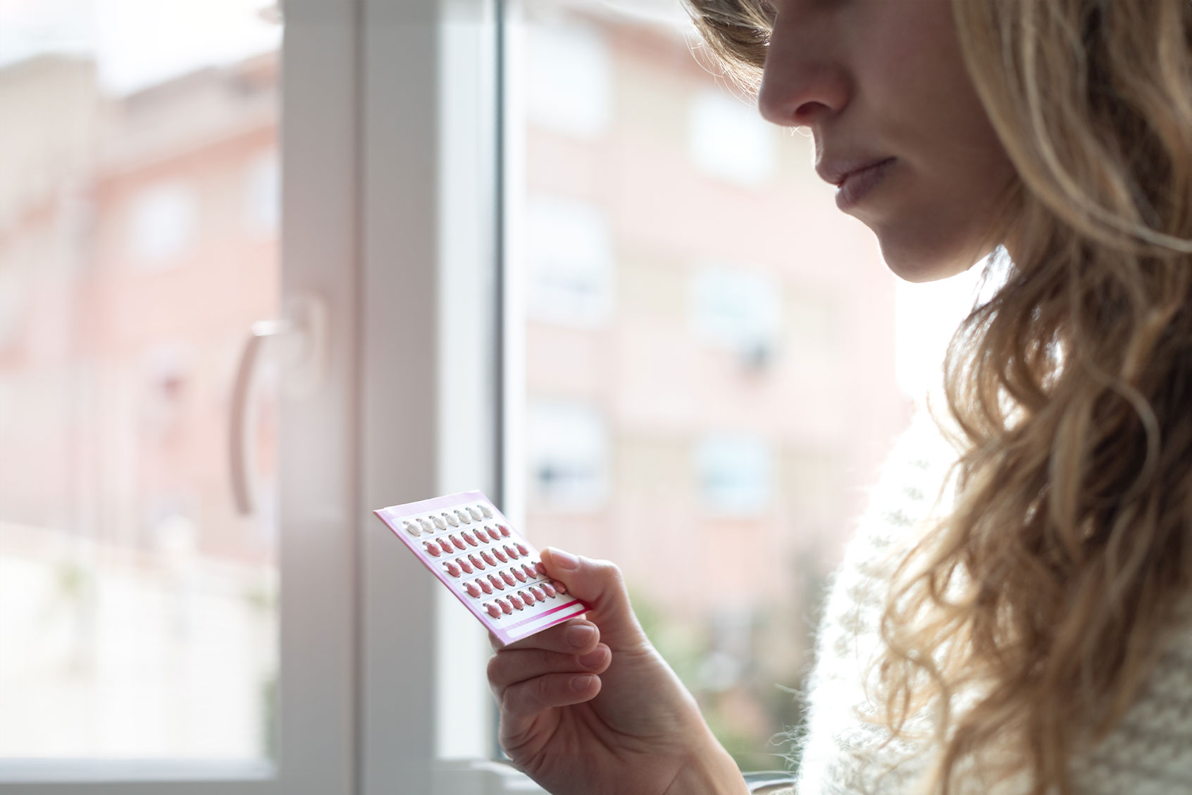 Young woman holding contraceptive pills (Getty Images/Cris Cantón)