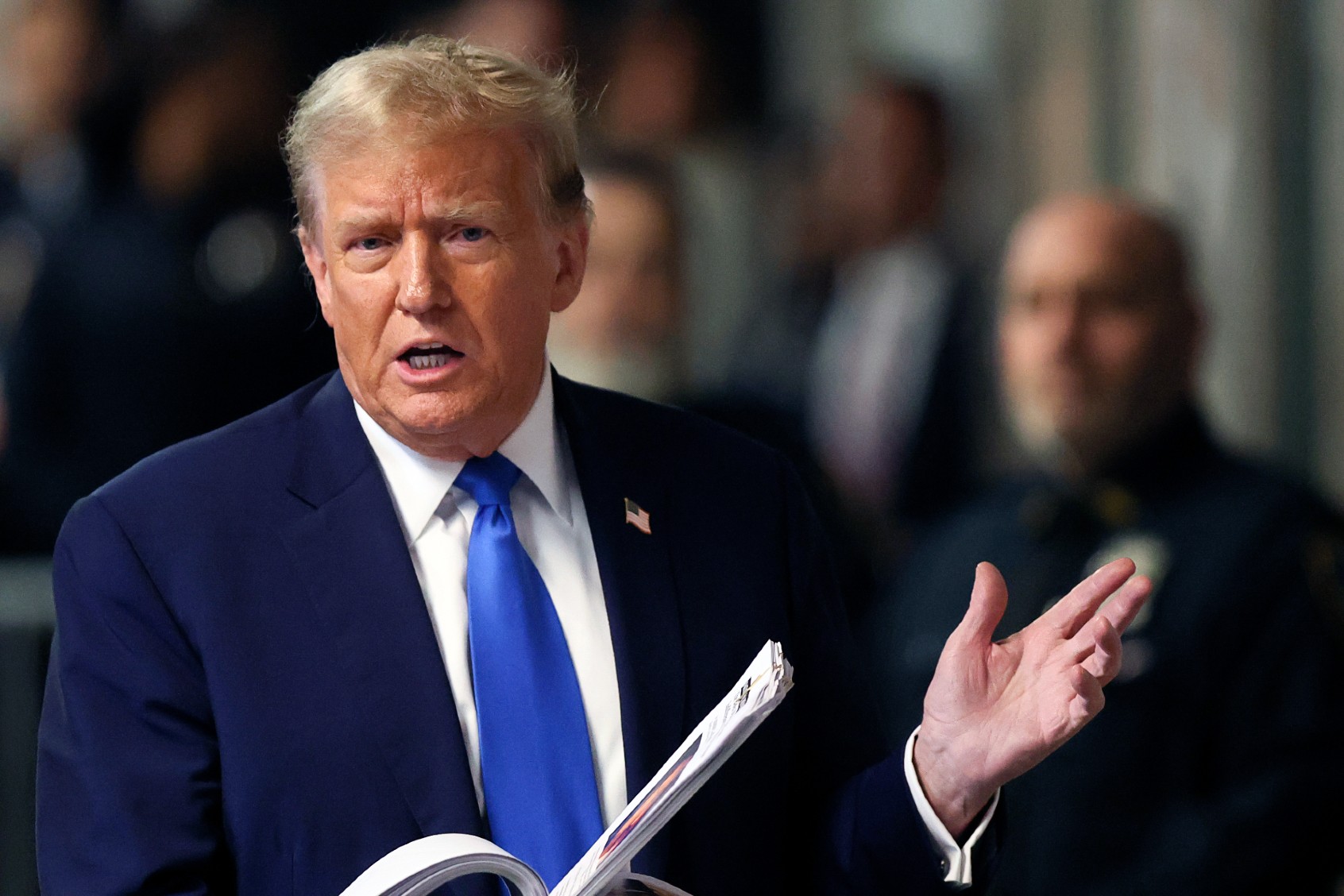 Former U.S. President Donald Trump holds news clippings as he leaves court for the day at Manhattan Criminal Court on April 18, 2024 in New York City. (Brendan McDermid-Pool/Getty Images)