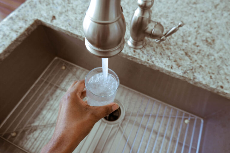 Close-up of a woman filling a glass of water from the kitchen faucet (Getty Images/Grace Cary)