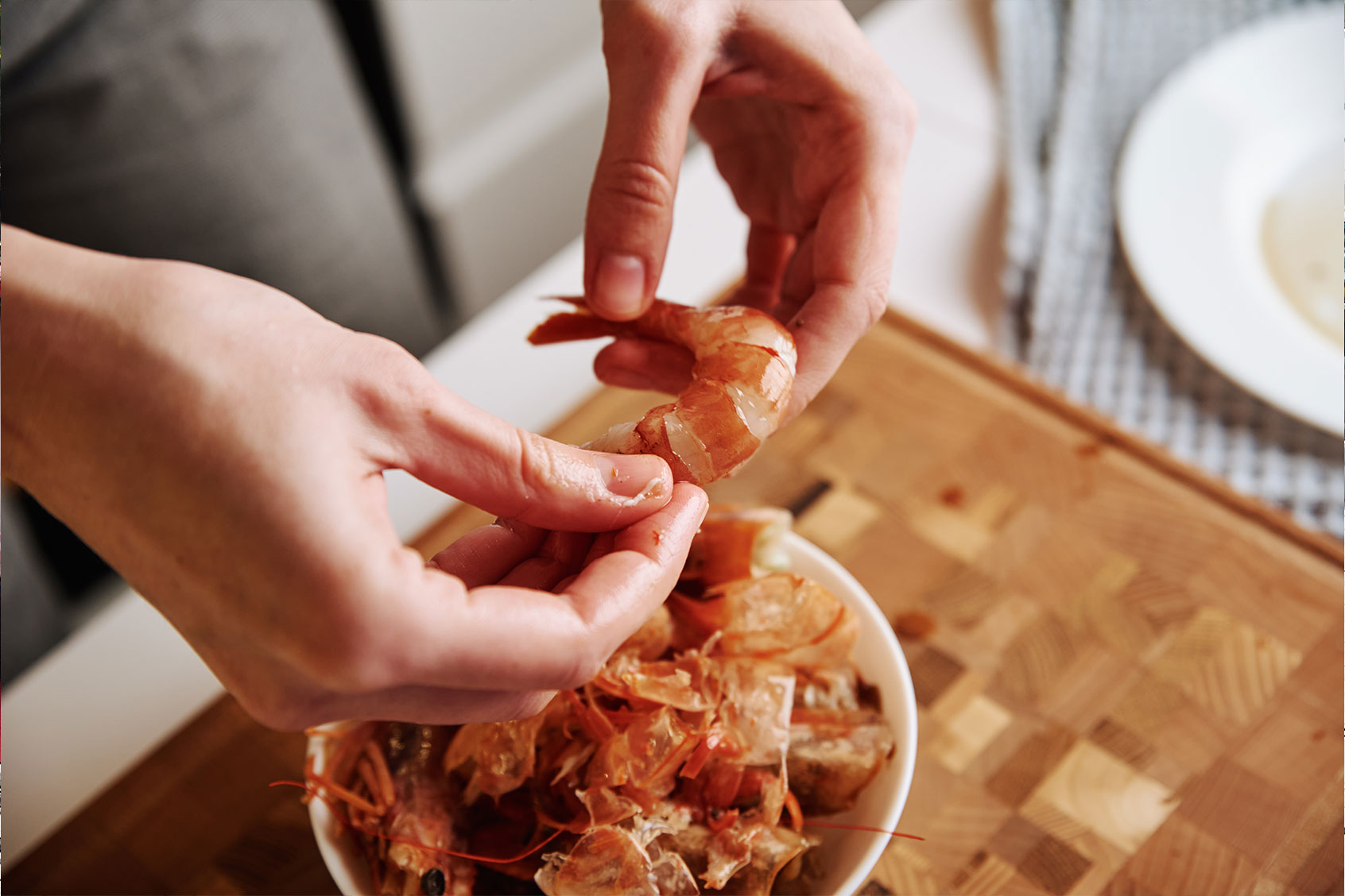 Woman cleaning shrimps for cooking. (Getty Images/Lazy_Bear)