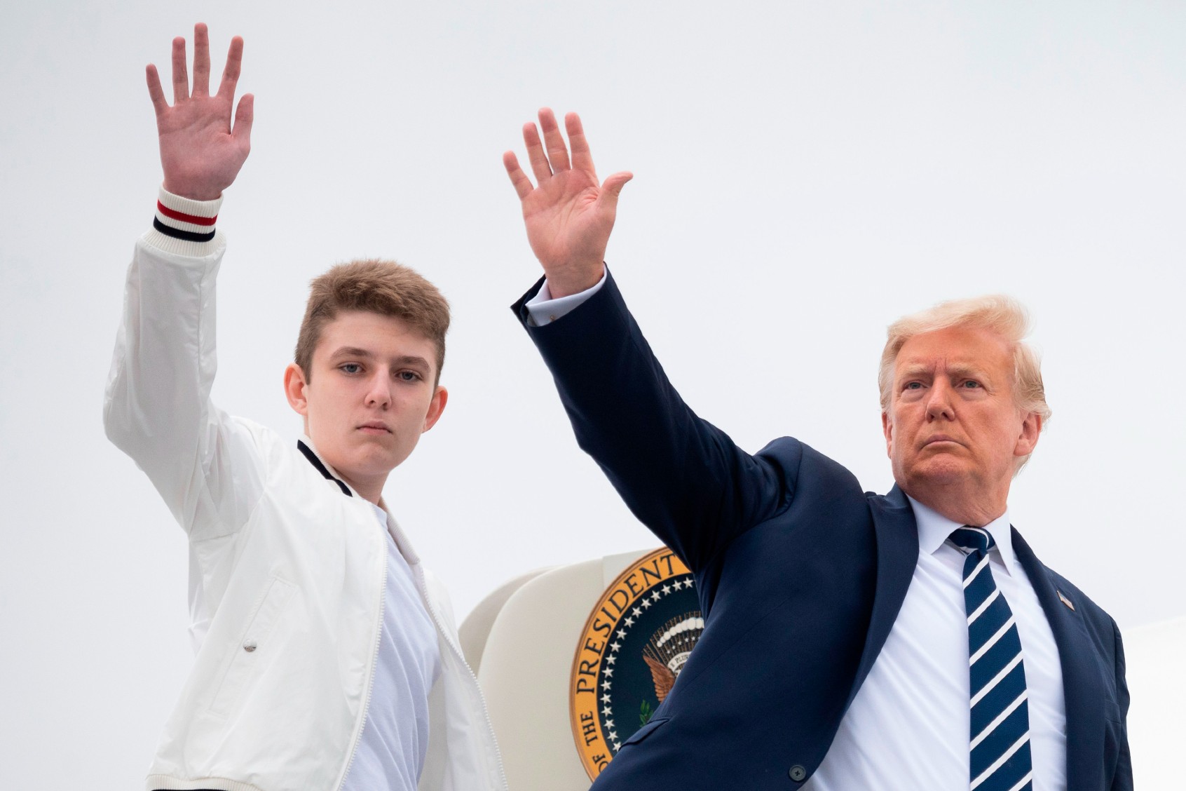 Former U.S. President Donald Trump and his son Barron wave as they board Air Force One at Morristown Municipal Airport in Morristown, New Jersey, on August 16, 2020. (JIM WATSON/AFP via Getty Images)