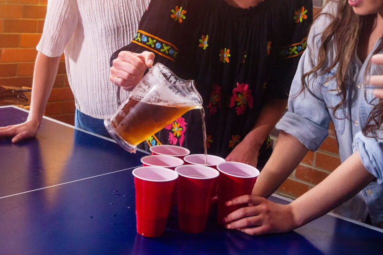 Woman holding pitcher with beer and pouring drinks at a party (Getty Images/stellalevi)