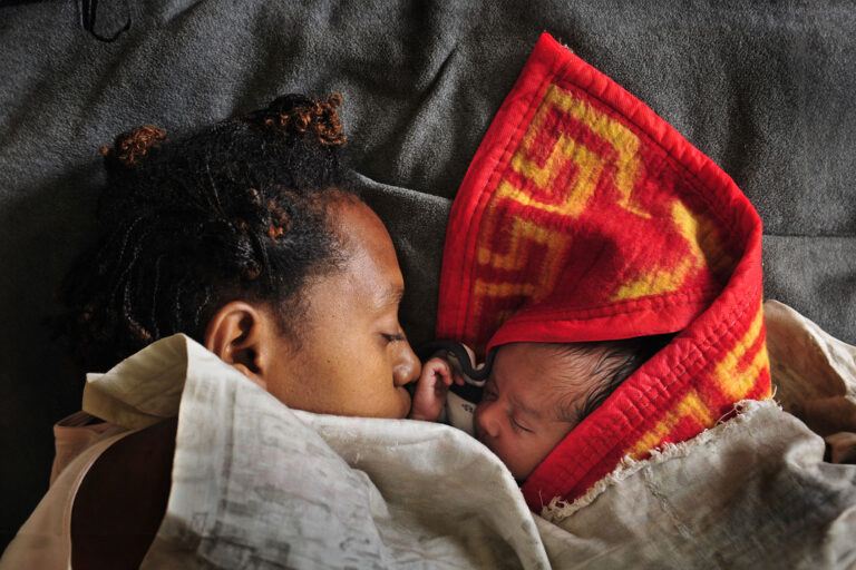 A woman sleeps with her baby in the maternity ward of a hospital on August 14, 2009 in Goroka in the Eastern Highlands province of Papua New Guinea. (Jason South/Fairfax Media via Getty Images)