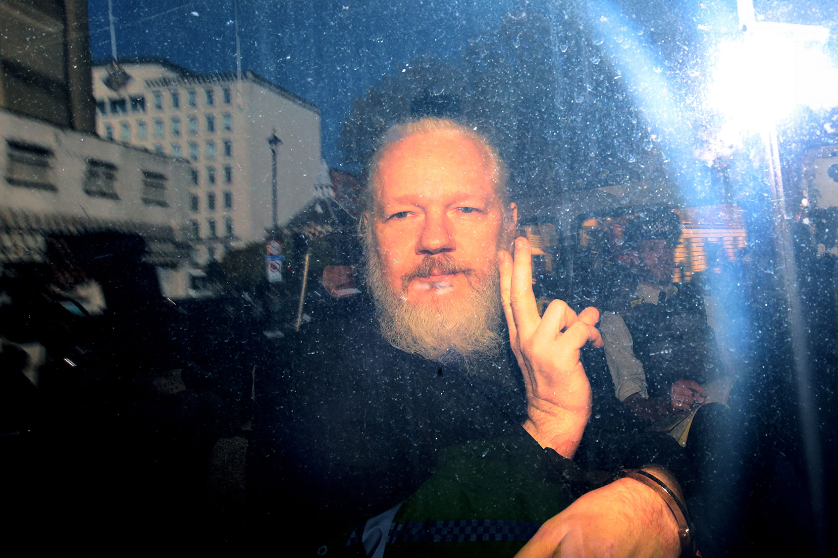 Julian Assange gestures to the media from a police vehicle on his arrival at Westminster Magistrates court on April 11, 2019 in London, England. (Jack Taylor/Getty Images)