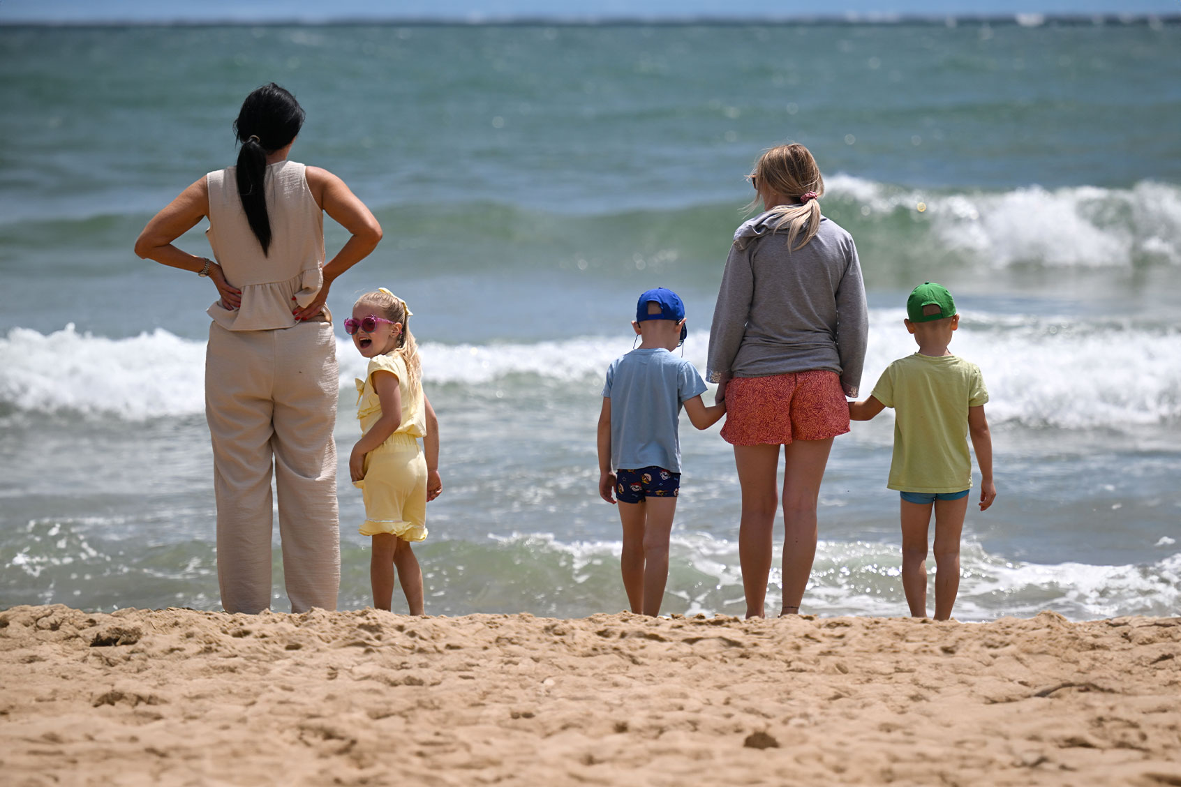 People stand by the sea at Bournemouth beach, on June 22, 2024 in Bournemouth, United Kingdom. Hotter weather is forecast at the start of next week, with temperatures reaching the mid-20s with potential heatwaves in some areas of central and southern England. (Finnbarr Webster/Getty Images)