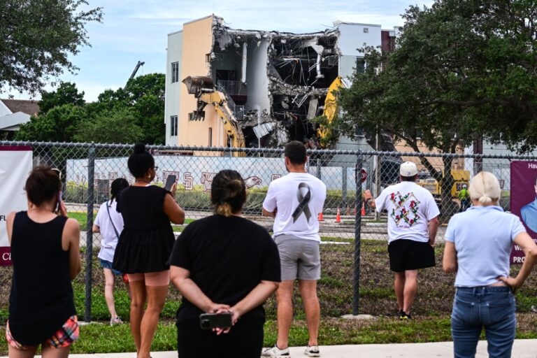 People watch as crews begin to demolish the building where seventeen people were killed during the 2018 mass shooting at Marjory Stoneman Douglas High School in Parkland, Florida, on June 14, 2024. (GIORGIO VIERA/AFP via Getty Images)