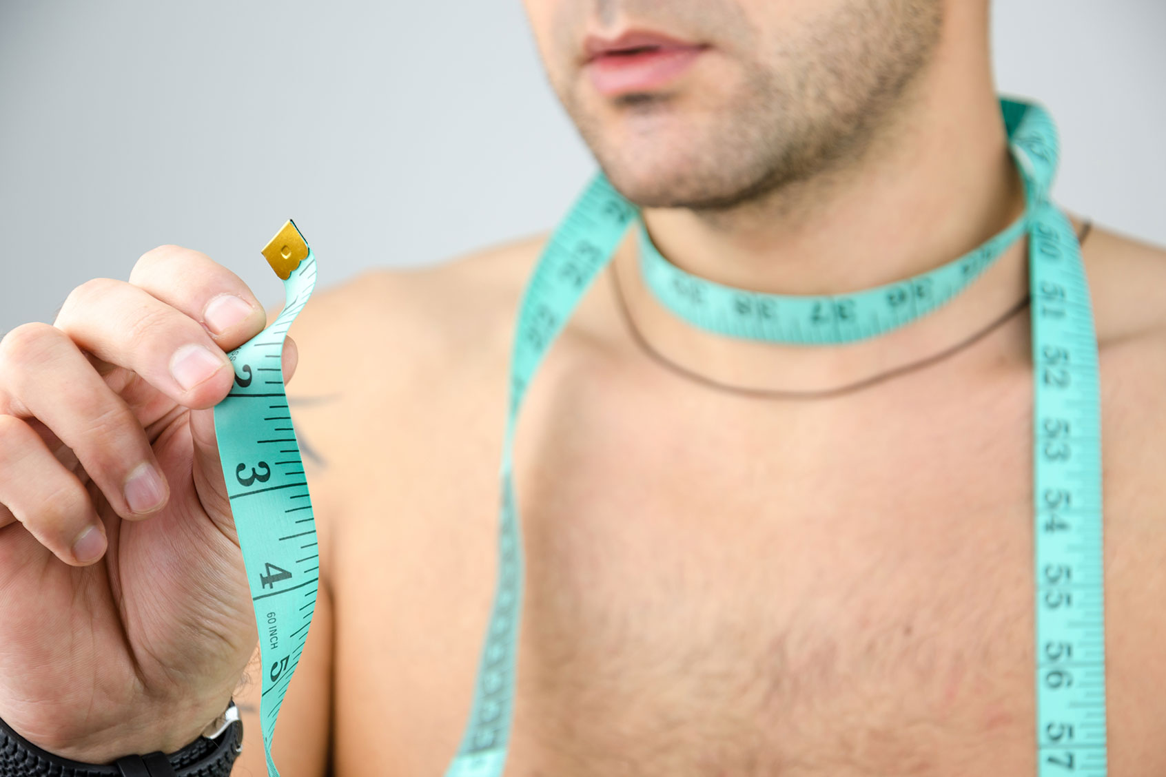 Man measuring his neck (Getty Images/RobertoDavid)