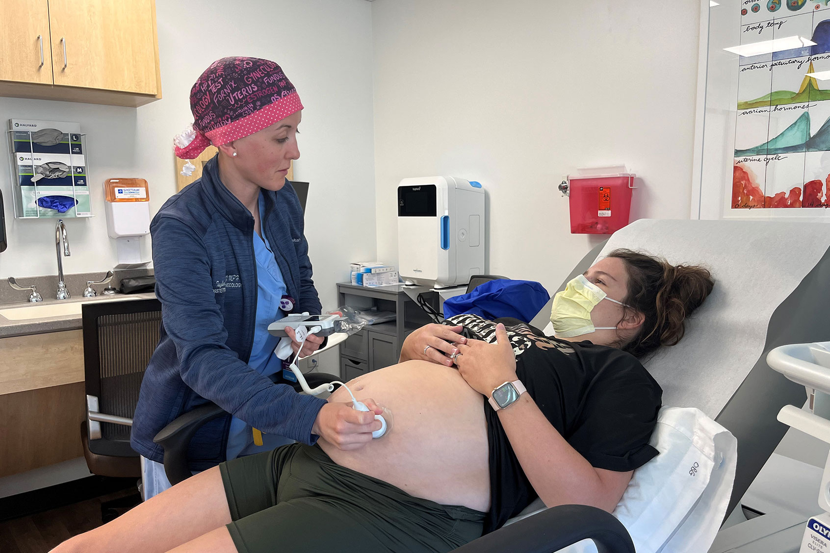 Obstetrician and gynecologist Taylar Swartz uses an ultrasound scanner to check the health of Addie Comegys’ baby on May 30, 2024. (Tony Leys/KFF Health News)