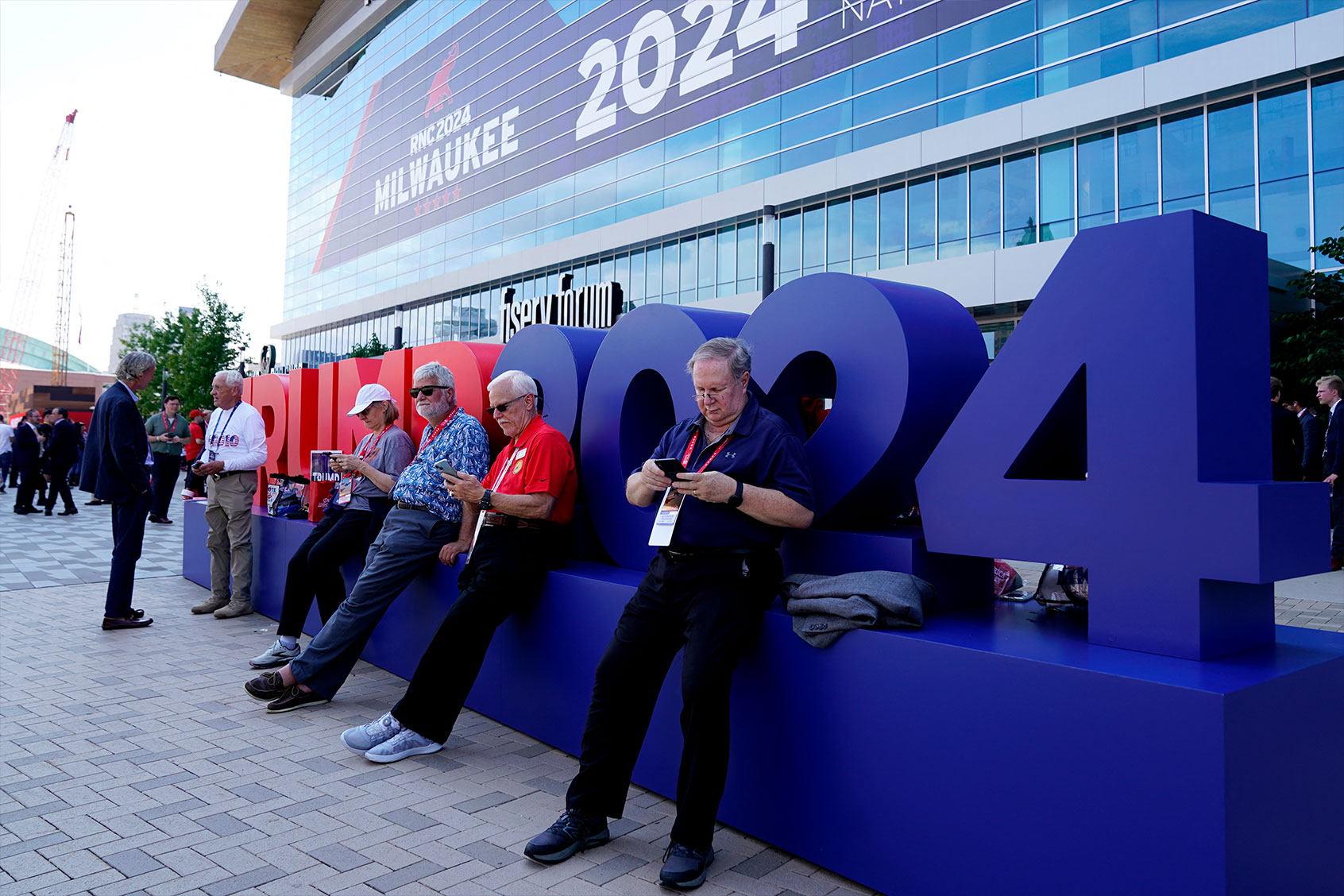 Attendees sit outside the Fiserv Forum during the second day of the 2024 Republican National Convention in Milwaukee, Wisconsin, July 16, 2024. (NICK OXFORD/AFP via Getty Images)
