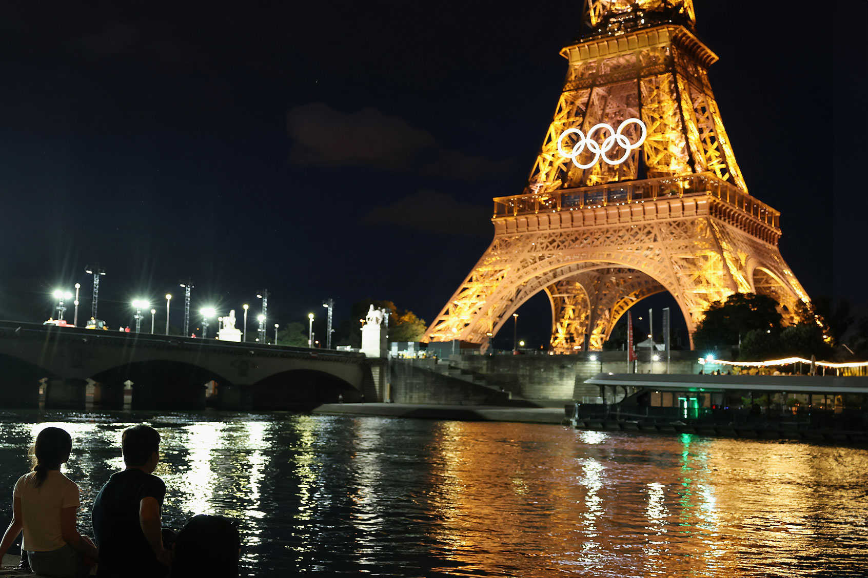 Spectators view the Eiffel Tower and Olympic rings along the Seine river on July 21, 2024 in Paris, France. (Christian Petersen/Getty Images)