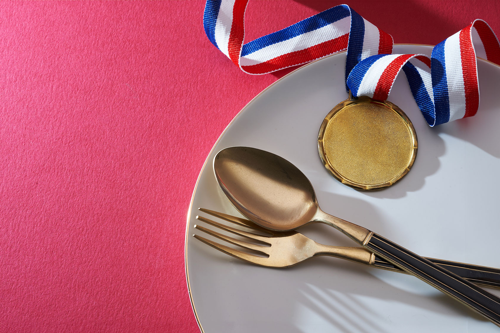 Gold medal on the dinner plate with fork and spoon (Getty Images /	seng kui Lim / 500px)