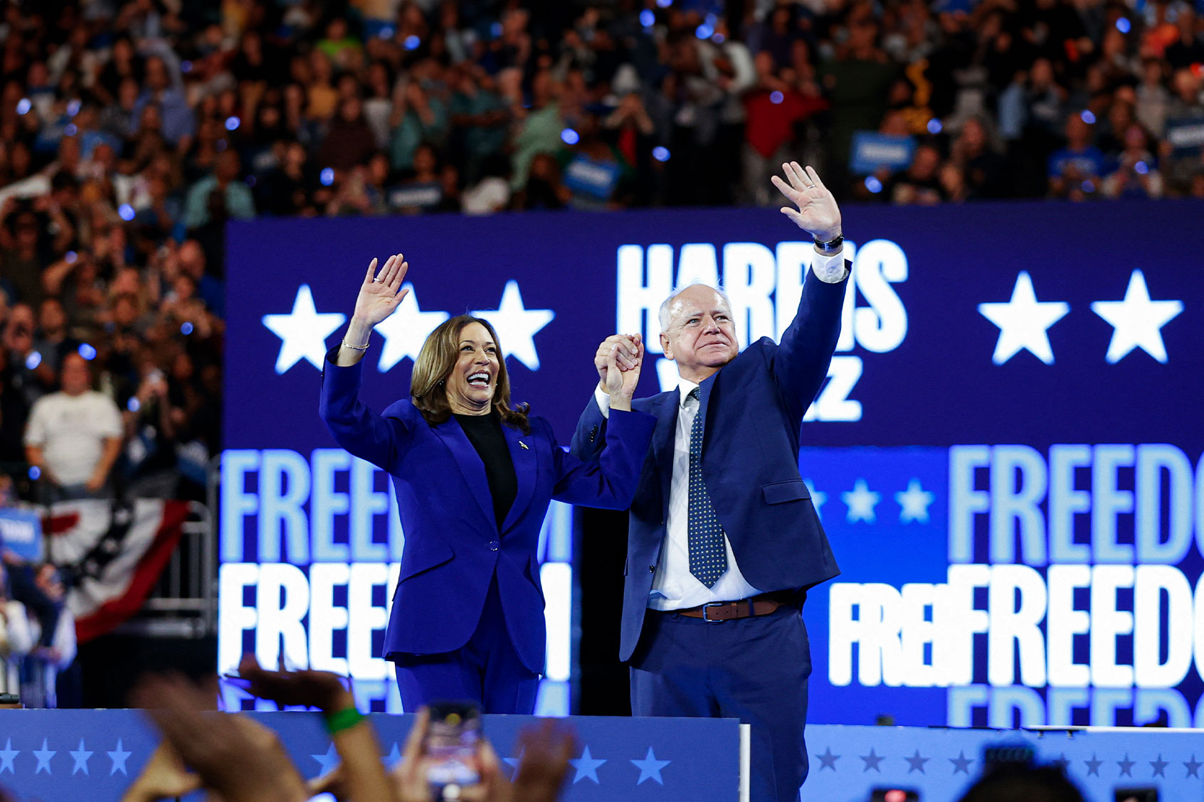 US Vice President and 2024 Democratic presidential candidate Kamala Harris and her running mate Minnesota Governor Tim Walz wave to the crowd after speaking at the campaign rally at the Fiserv Forum in Milwaukee, Wisconsin, August 20, 2024. (KAMIL KRZACZYNSKI/AFP via Getty Images)
