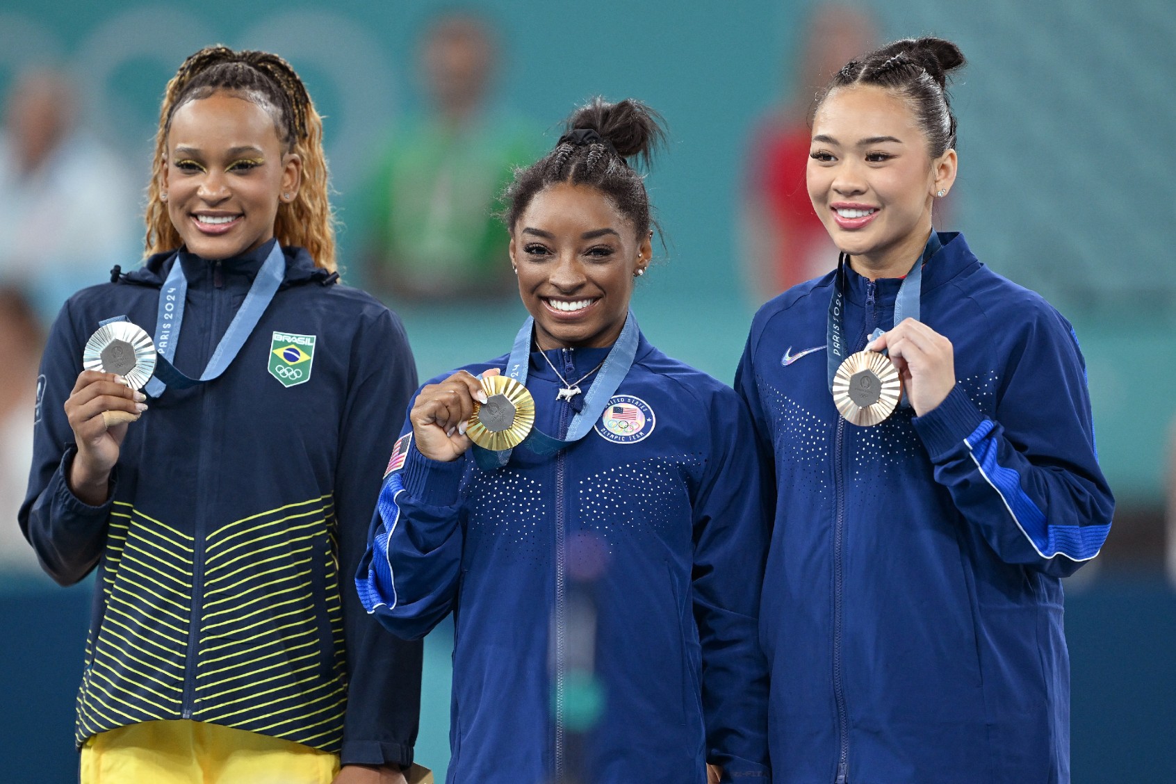 Bronze medal, US' Sunisa Lee, winner gold medal US' Simone Biles and Brazilian Rebeca Andrade celebrate on the podium after the women's all-around final of gymnastics competition at the Paris 2024 Olympic Games, on Thursday 01 August 2024 in Paris, France. ( ANTHONY BEHAR/BELGA MAG/AFP via Getty Images)