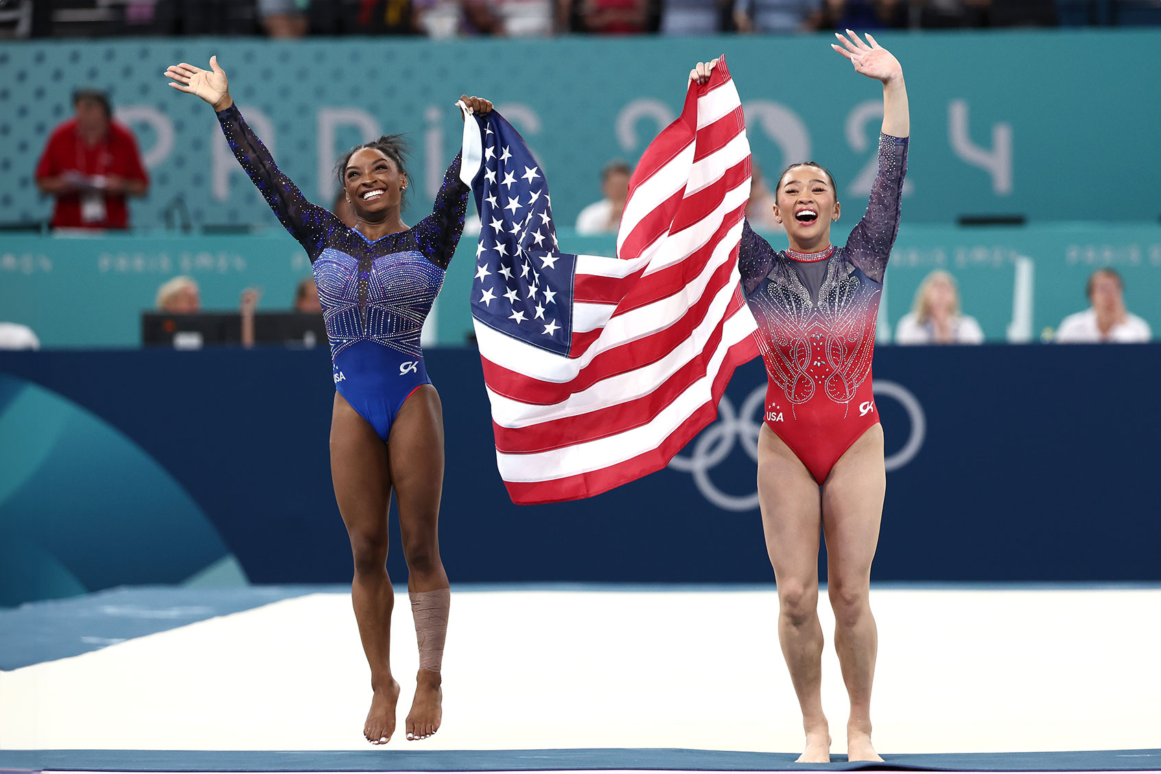 Gold medalist Simone Biles (L) and Bronze medalist Sunisa Lee of Team United States celebrate with the American flag after competing in the Artistic Gymnastics Women's All-Around Final on day six of the Olympic Games Paris 2024 at Bercy Arena on August 01, 2024 in Paris, France. (Naomi Baker/Getty Images)