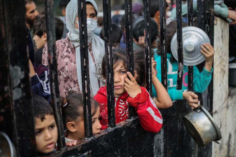 Citizens queue for food that is cooked in large pots and distributed for free during war-time on December 28, 2023 in Rafah, Gaza. (Ahmad Hasaballah/Getty Images)