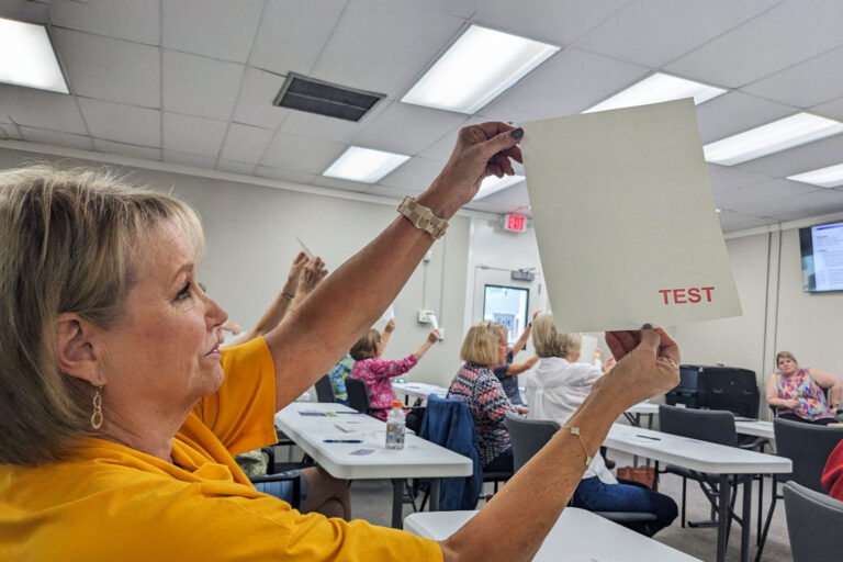 Lee County poll workers look for watermarks on voting paper during poll worker training in Leesburg, Georgia on October 2, 2024. (BECCA MILFELD/AFP via Getty Images)