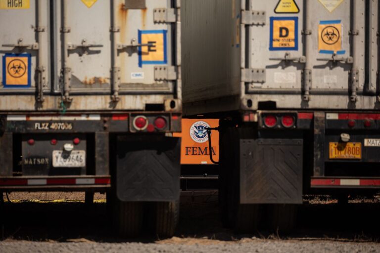 A FEMA logo is pictured behind a refrigerated storage container adjacent to the Maui Police Forensic Facility where human remains are stored in the aftermath of the Maui wildfires in Wailuku, Hawaii on August 17, 2023. (Photo by YUKI IWAMURA/AFP via Getty Images)
