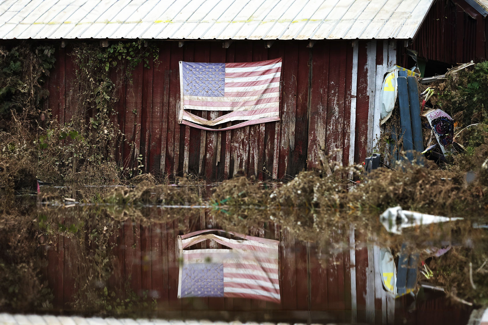 An American flag is reflected in floodwaters remaining from Hurricane Helene on October 4, 2024 in Swannan, North Carolina. (Mario Tama/Getty Images)