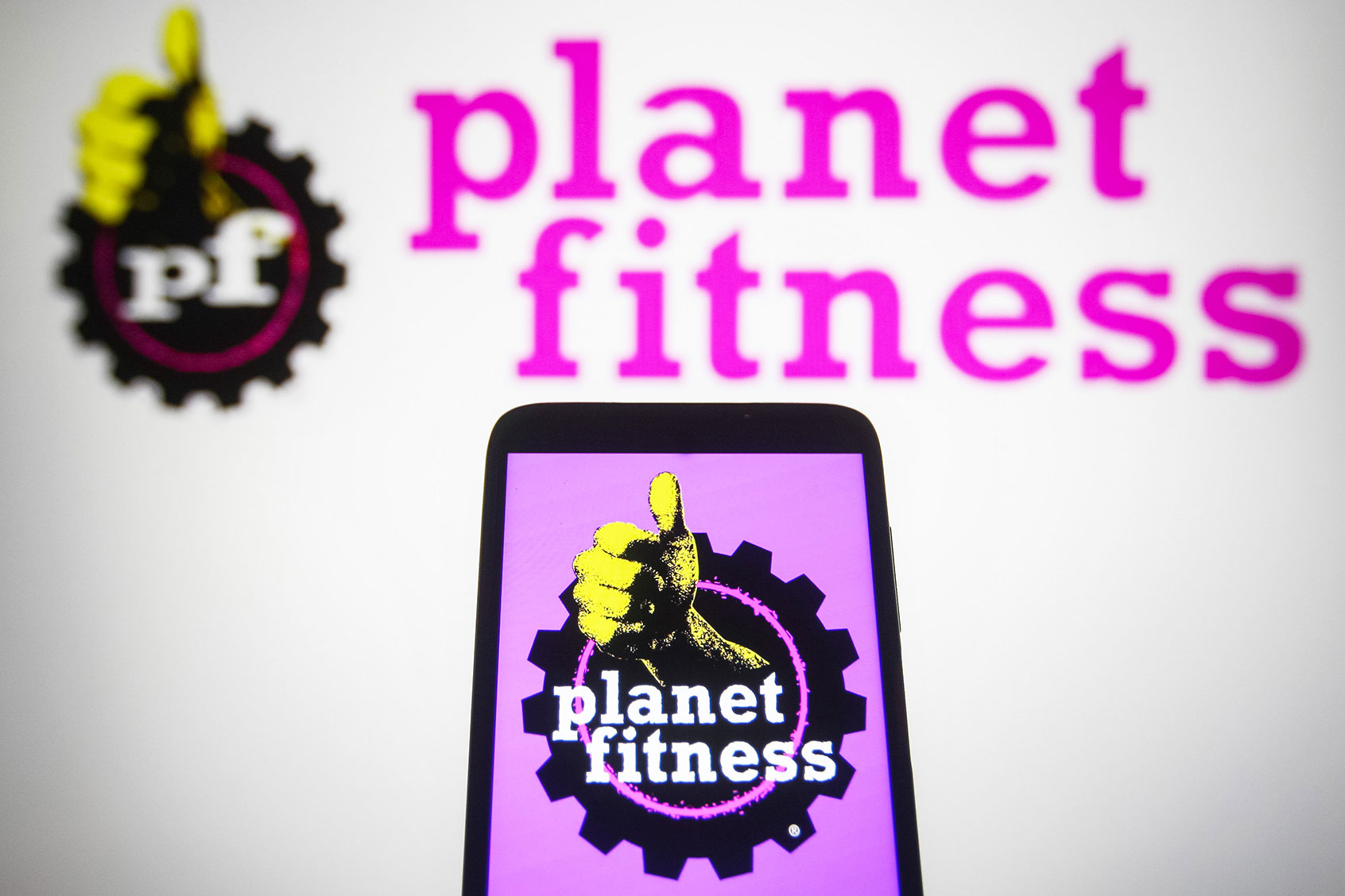 Planet Fitness (PFIP LLC) logo is seen displayed on a smartphone and a pc screen. (Pavlo Gonchar/SOPA Images/LightRocket via Getty Images)