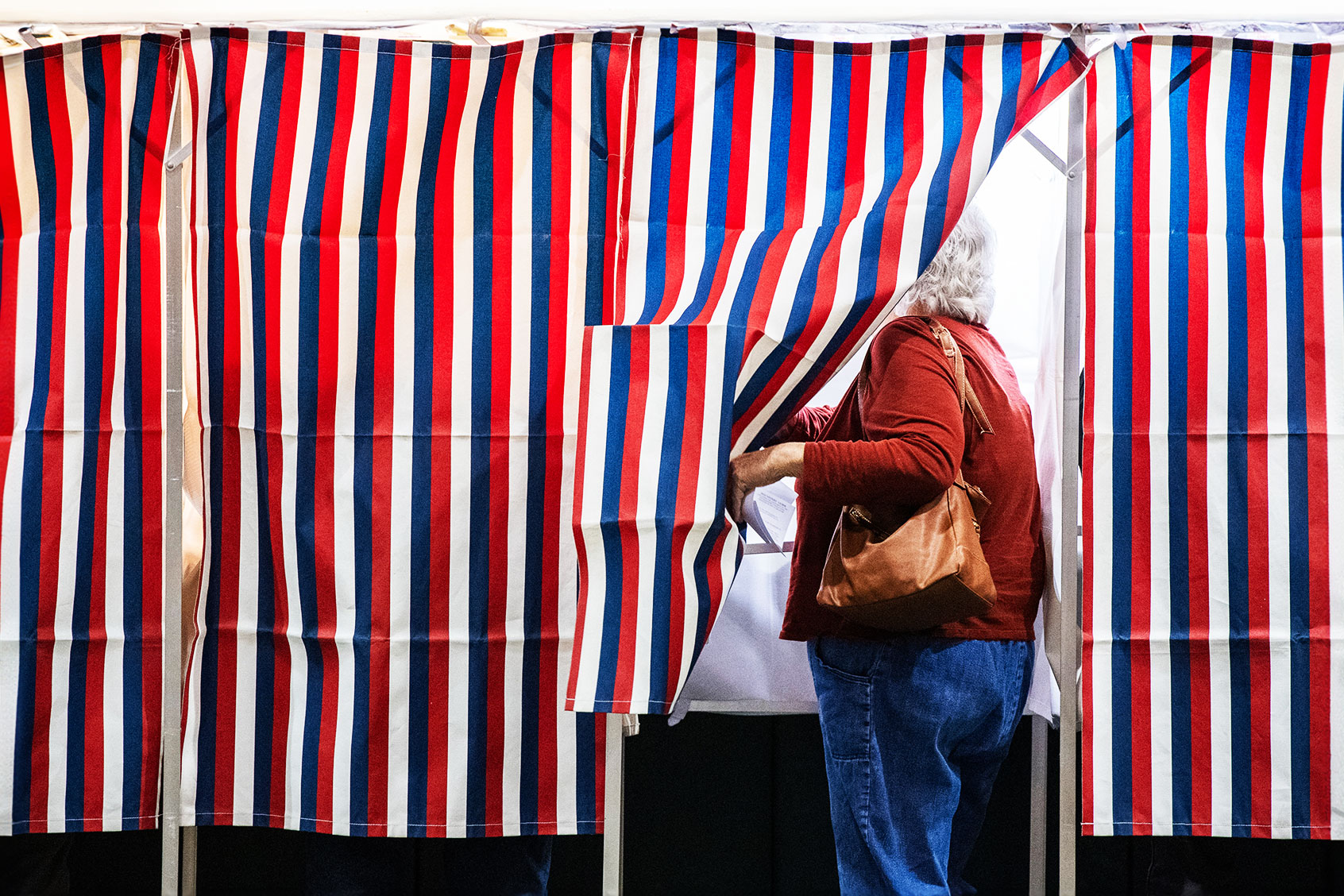 A person enters a voting booth at a polling station at Colebrook Academy and Elementary School in Colebrook, New Hampshire, on Election Day, November 5, 2024. (JOSEPH PREZIOSO/AFP via Getty Images)