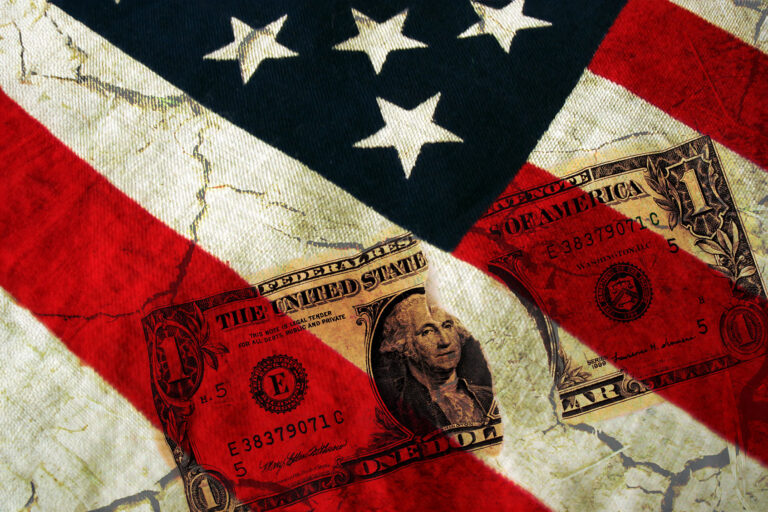 American flag and a ripped dollar bill (Getty Images/sdominick)