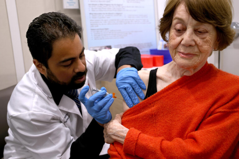 Dr. Gaurav Shinde gives a patient her vaccinations for COVID and her flu shot at the Walgreens pharmacy in Torrance, California on September 5, 2024. (Genaro Molina/Los Angeles Times via Getty Images)